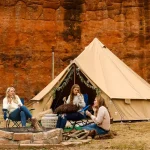 family enjoying outdoors in mountains with family camping tent