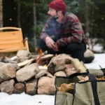 men setting up campfire with firewood carrier beside