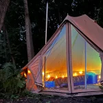 glamping tent with lighting setup in forest for luxury and cozy outdoor experience