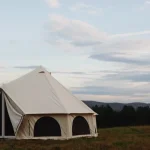 A durable canvas camping tent set up in a scenic outdoor location, perfect for camping trips and adventures.