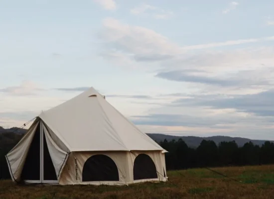 A durable canvas camping tent set up in a scenic outdoor location, perfect for camping trips and adventures.