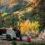 verlanding campsite in autumn forest with mountains.