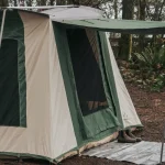 A cabin tent with a door and a window, designed for camping in nature