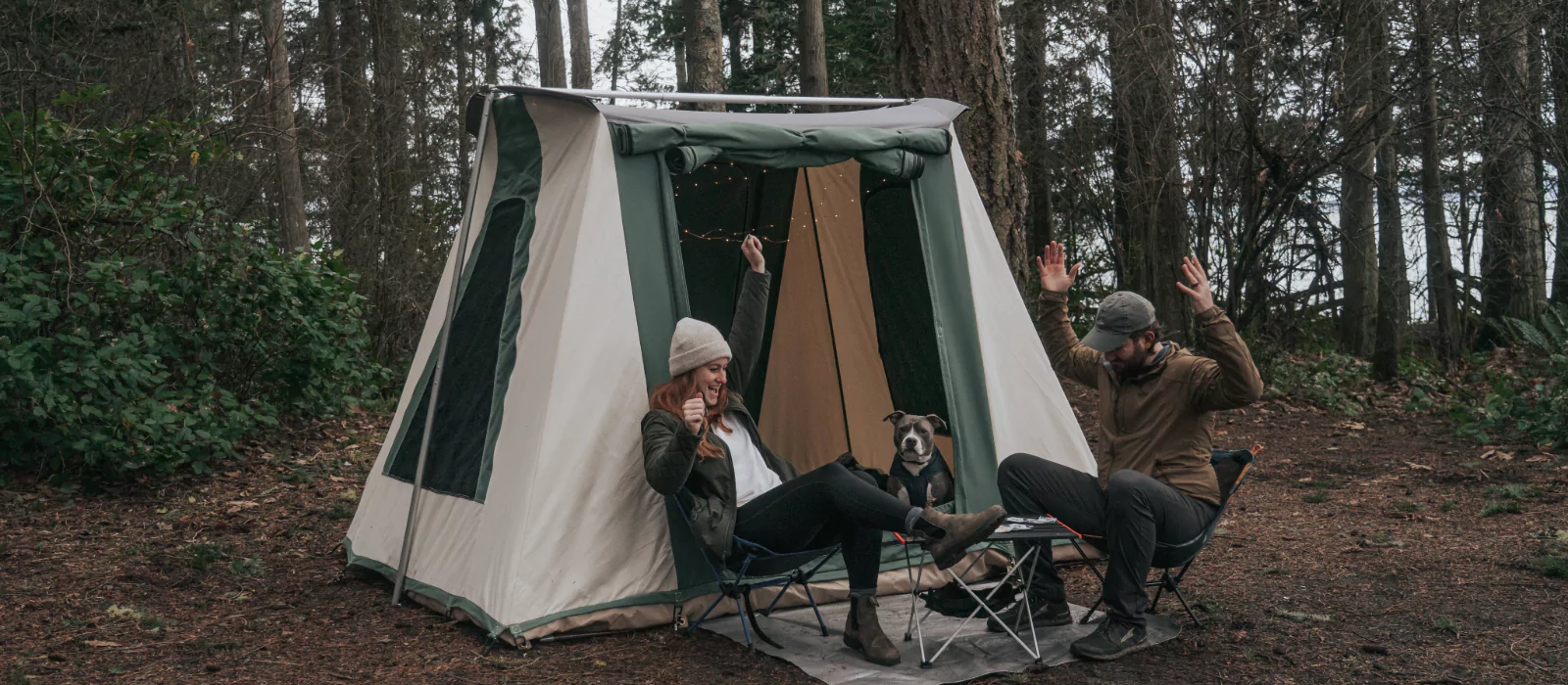 Campers dealing with common camping issues outside a canvas tent in the forest