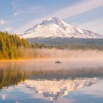 Scenic camping spot in the U.S. with a lake view and snow-capped mountain in the background.