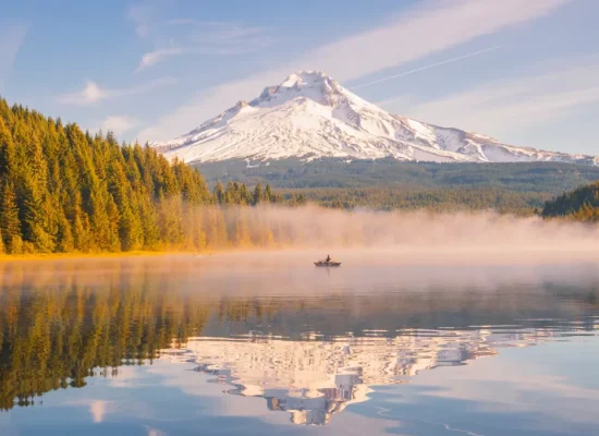 Scenic camping spot in the U.S. with a lake view and snow-capped mountain in the background.