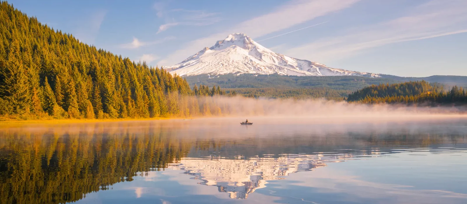 Scenic camping spot in the U.S. with a lake view and snow-capped mountain in the background.