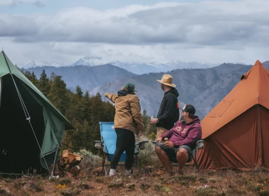 Friends camping with canvas tents in the mountains