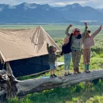 Kids camping trip with family tent in the mountains, children enjoying outdoor adventure in nature