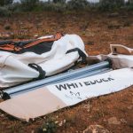 Tent poles and camping hardware from WhiteDuck Outdoors laid out on the ground before setup.