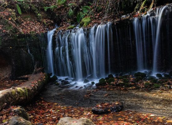 Peaceful waterfall surrounded by rocks and forest, perfect spot for camping near nature and running water
