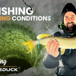 Man holding a fish caught while ice fishing in freezing conditions, standing near an ice hole with the text “Ice Fishing in Freezing Conditions – Wandering with WhiteDuck.”