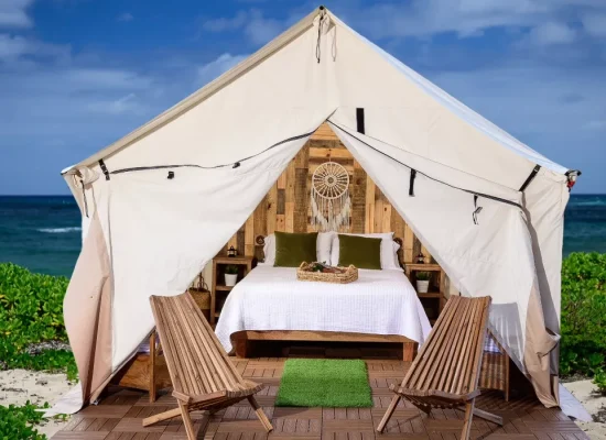 Stylish glamping tent at a beach campsite with ocean view and cozy bed setup