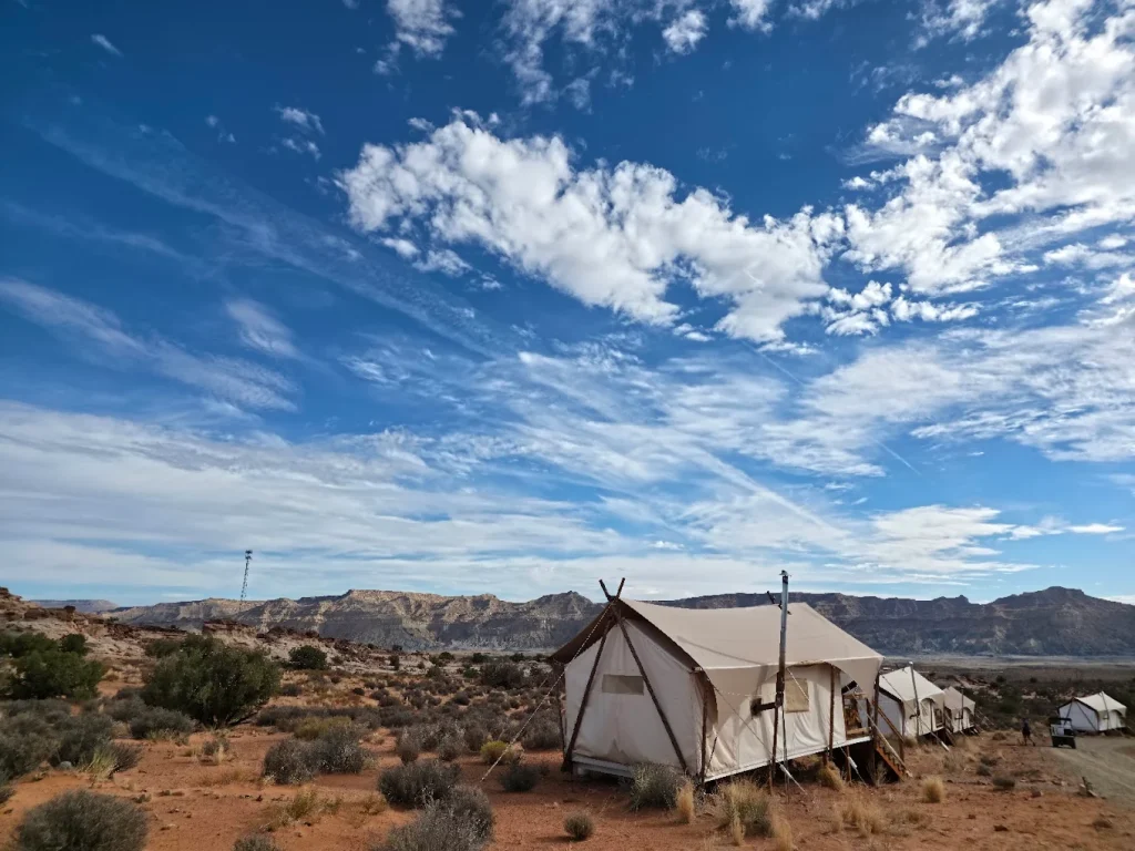 A row of luxury safari-style glamping tents with tan canvas and wooden frames at Under Canvas Lake Powell.