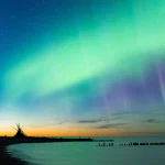 Aurora Borealis illuminating the night sky above Lake Superior in Michigan's Upper Peninsula, a top Northern Lights viewing destination in the U.S.