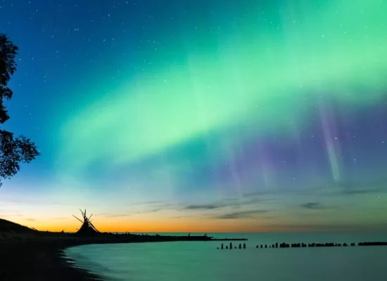 Aurora Borealis illuminating the night sky above Lake Superior in Michigan's Upper Peninsula, a top Northern Lights viewing destination in the U.S.