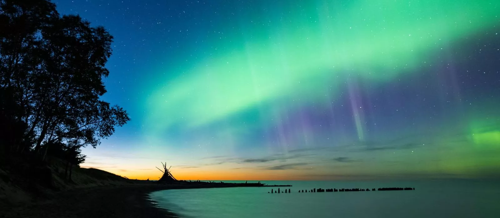Aurora Borealis illuminating the night sky above Lake Superior in Michigan's Upper Peninsula, a top Northern Lights viewing destination in the U.S.