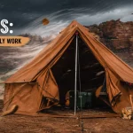 Canvas camping tent securely anchored with guy lines during strong winds, illustrating effective high wind tent setup techniques in a rugged desert campsite