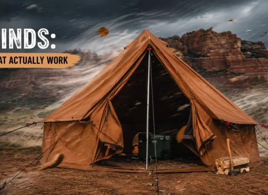 Canvas camping tent securely anchored with guy lines during strong winds, illustrating effective high wind tent setup techniques in a rugged desert campsite
