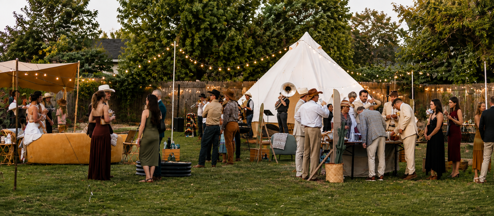 Backyard micro wedding with guests gathered around a white bell tent and string lights