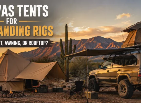 Canvas ground tent and overlanding SUV with rooftop tent and awning at a desert campsite during sunset.