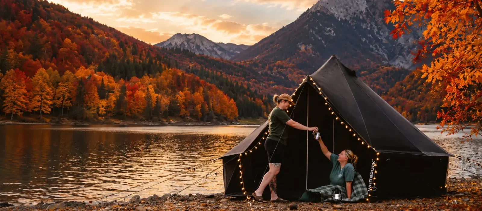 Fall foliage glamping with a canvas tent beside a mountain lake surrounded by colorful autumn trees