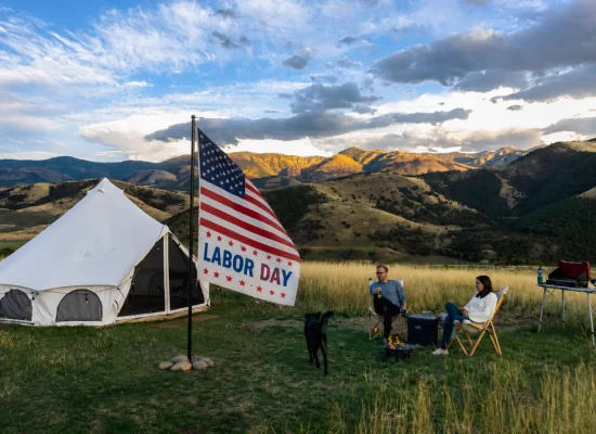 Labor Day camping trip with a white bell tent and American flag in a mountain campsite