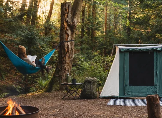 Jess reading in a hammock at a peaceful forest campsite